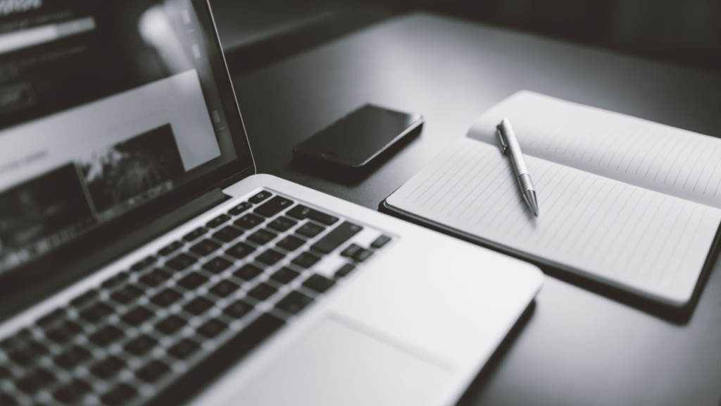 Laptop with notebook to create a Facebook marketing strategy
