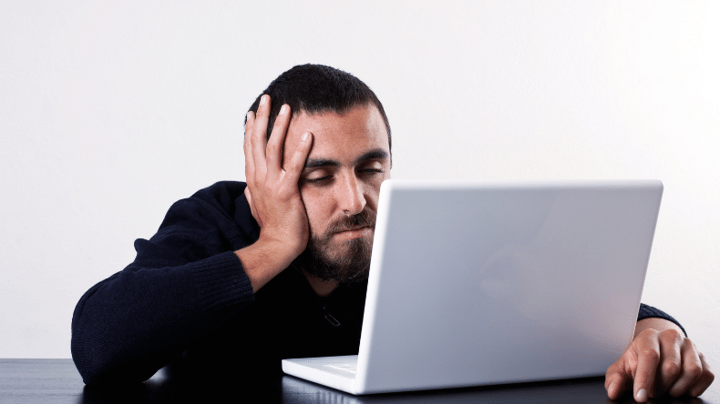 Man getting bored watching video on laptop